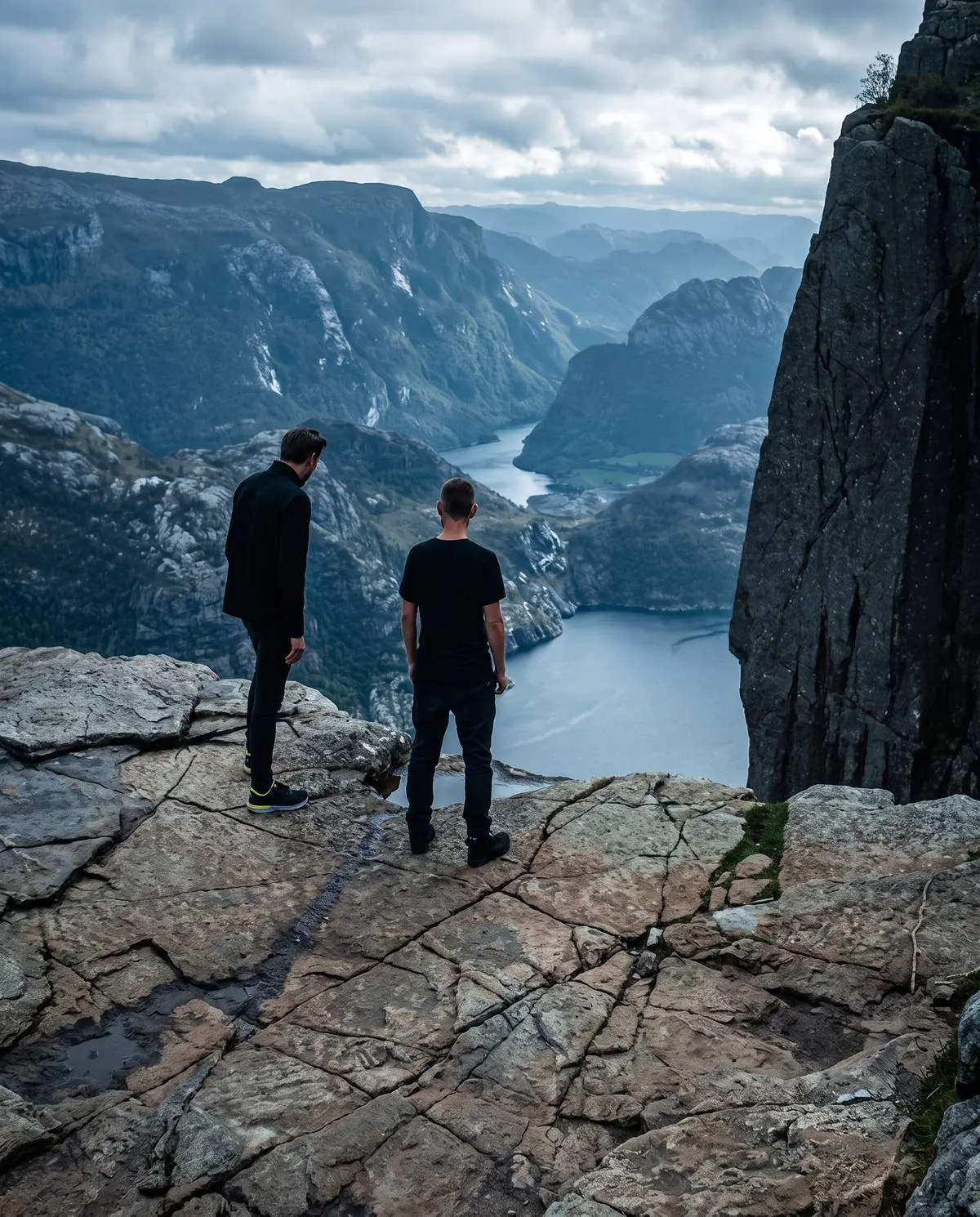 Two men looking across a mountain landscape