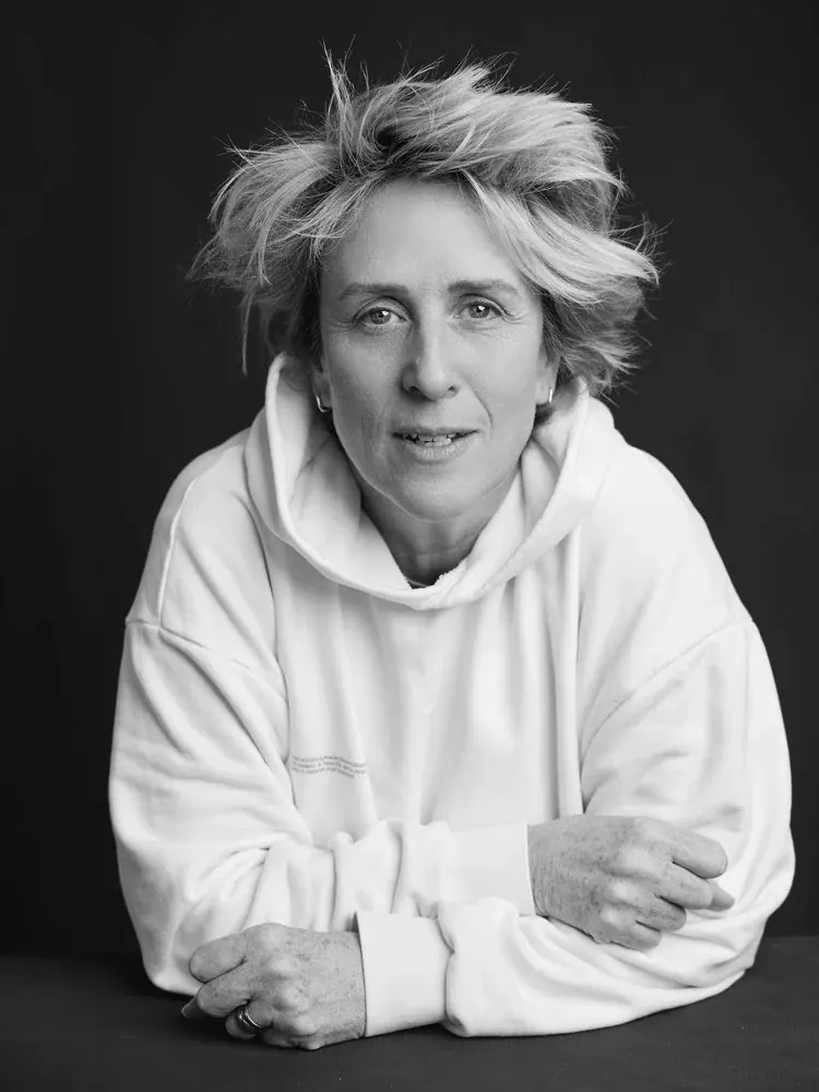 Black and white portrait of Stacey Key, arms folded on a table, wearing a white hoodie